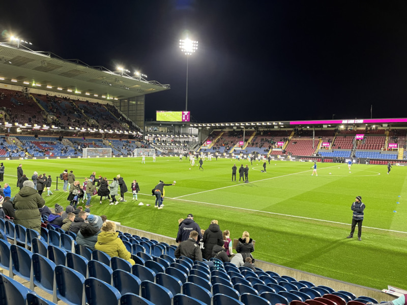 Turf Moor stadium at night, illuminated by the floodlights