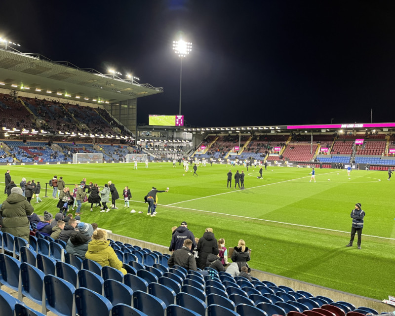 Turf Moor stadium at night, illuminated by the floodlights