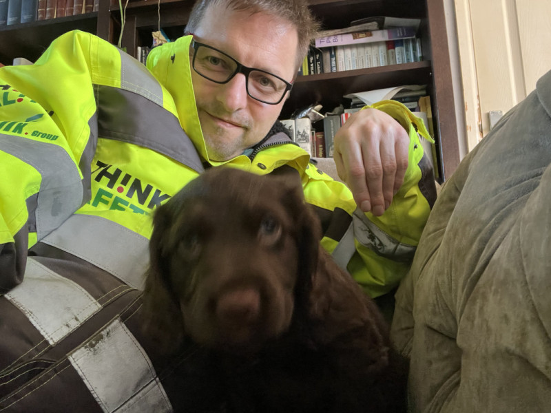 Selfie of me in a hi vis jacket with a working cocker puppy.