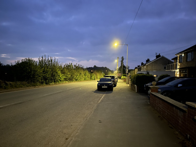 Barden Lane at night illuminated by street lighting, with fields to the left