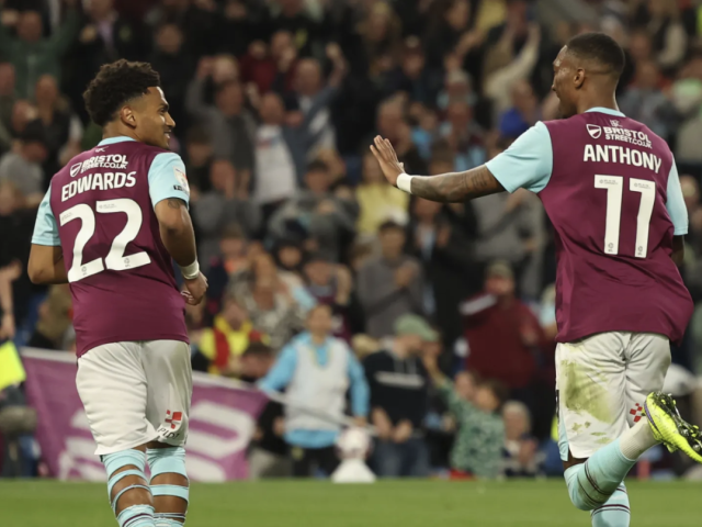 Image of Marcus Edwards and Jaidon Anthony running away from the camera and looking towards each other in 2024-5 season home kit, Edwards wearing number 22, and Anthony 11.