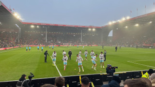 Burnley first 11 warm up in front of the away support at Bramall Lane in the mist.