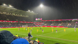 Bashir Humphreys directs a throw-in towards Josh Laurent against Leeds United at Turf Moor in  heavy rain, under floodlights